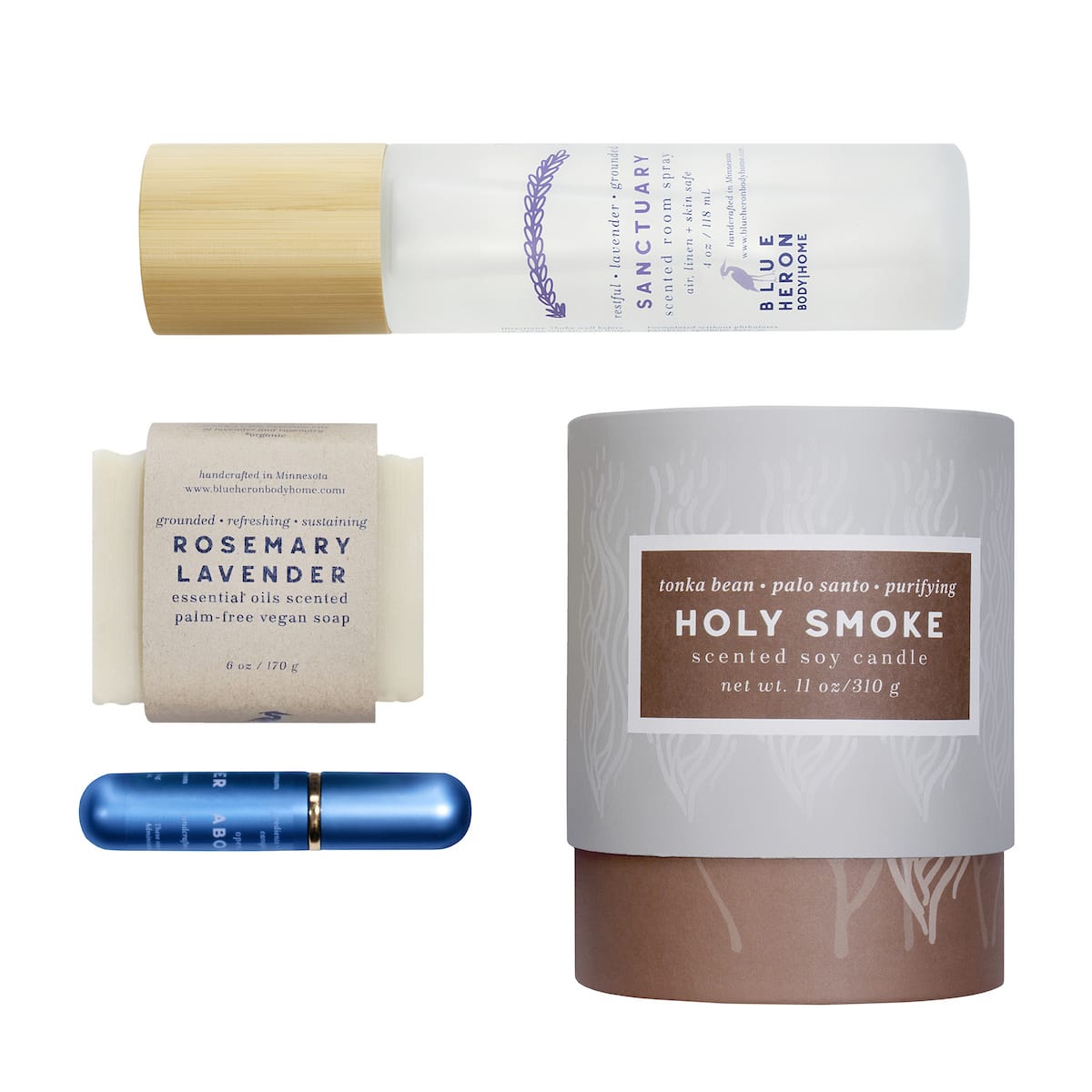 Collection of natural products including a candle, soap, room spray and inhaler on a white background