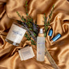 Palm-Free earth soap with inhaler, room spray and a candle on a satin surface with lavender and greenery.